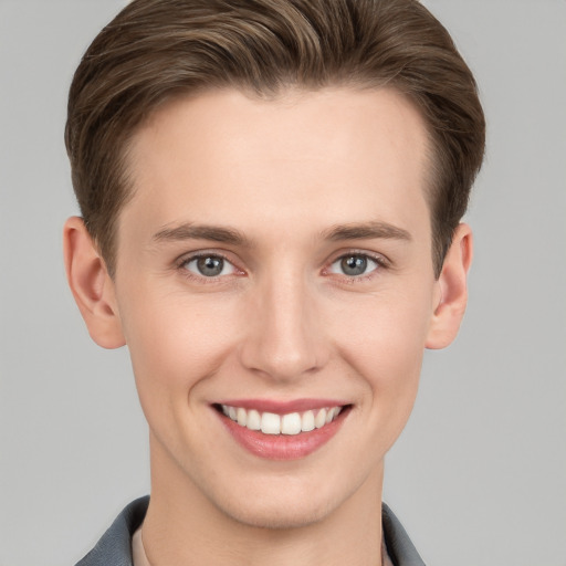 Joyful white young-adult male with short  brown hair and grey eyes