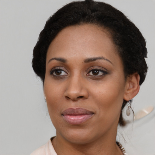 Joyful black young-adult female with short  black hair and brown eyes