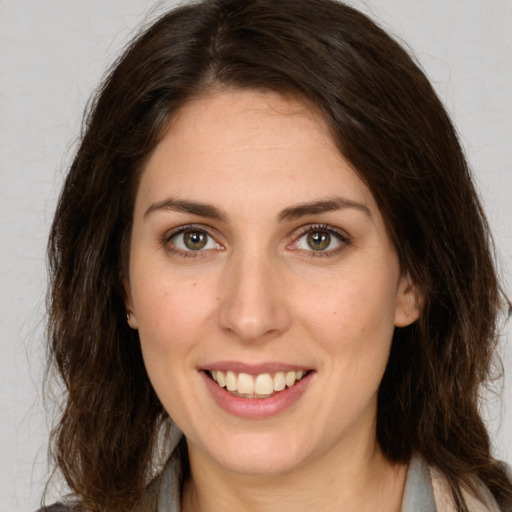 Joyful white young-adult female with long  brown hair and brown eyes