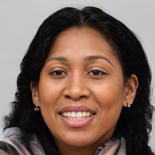 Joyful black adult female with long  brown hair and brown eyes