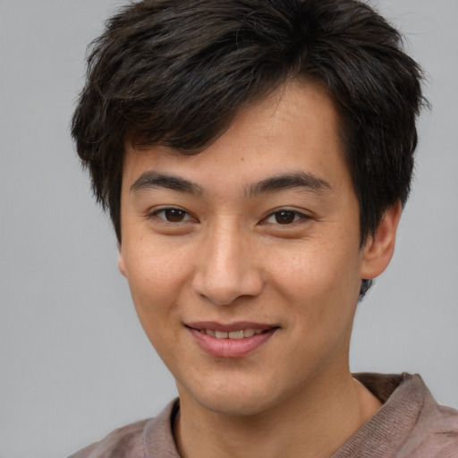 Joyful asian young-adult male with short  brown hair and brown eyes