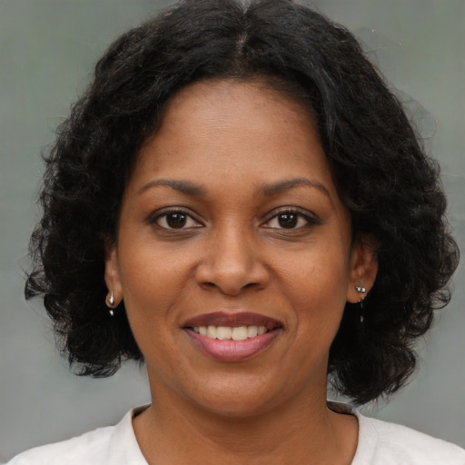 Joyful black young-adult female with medium  brown hair and brown eyes