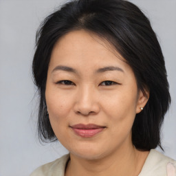 Joyful asian adult female with medium  brown hair and brown eyes