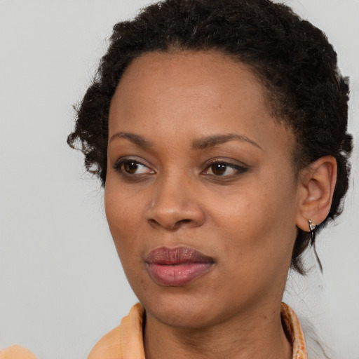 Joyful black young-adult female with short  brown hair and brown eyes