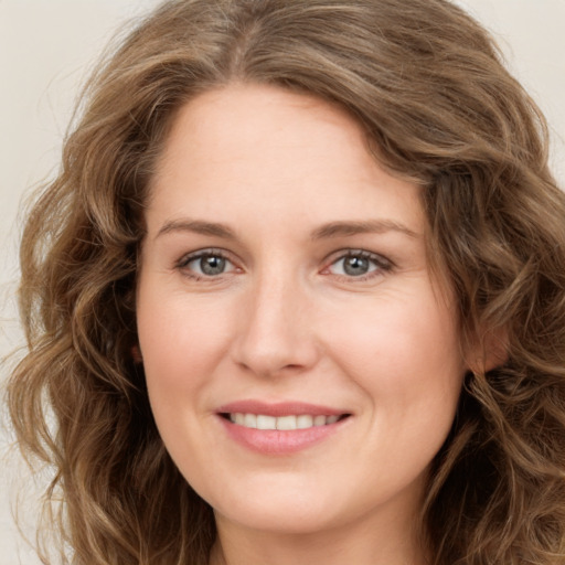 Joyful white young-adult female with long  brown hair and green eyes