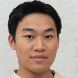 Joyful asian young-adult male with short  black hair and brown eyes