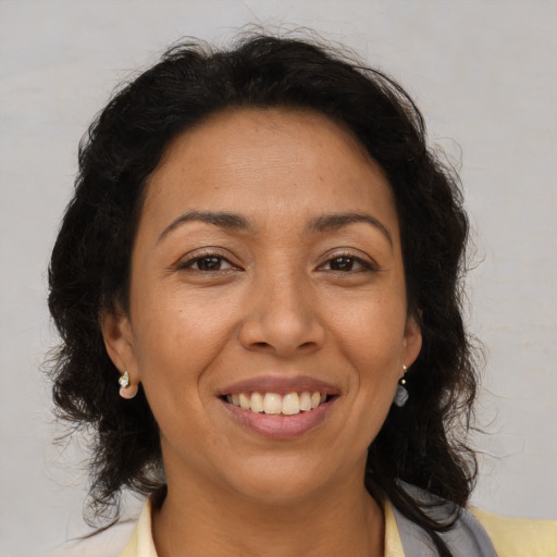 Joyful latino adult female with medium  brown hair and brown eyes