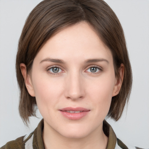 Joyful white young-adult female with medium  brown hair and grey eyes