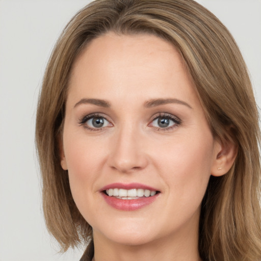 Joyful white young-adult female with long  brown hair and grey eyes