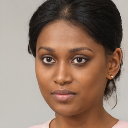 Joyful black young-adult female with medium  brown hair and brown eyes