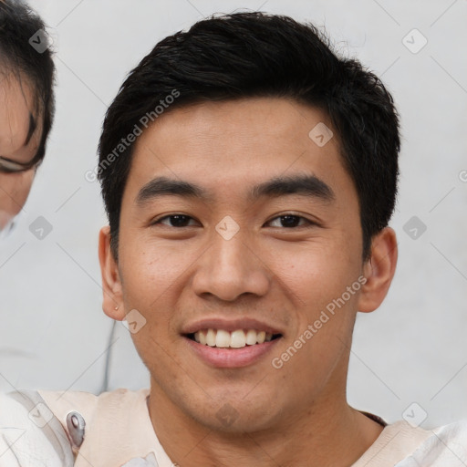 Joyful asian young-adult male with short  brown hair and brown eyes