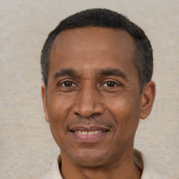 Joyful black adult male with short  black hair and brown eyes