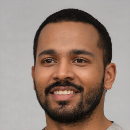 Joyful latino young-adult male with short  black hair and brown eyes