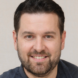 Joyful white adult male with short  brown hair and brown eyes