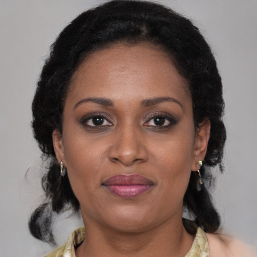 Joyful black adult female with medium  brown hair and brown eyes