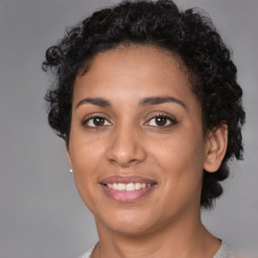 Joyful latino young-adult female with short  black hair and brown eyes