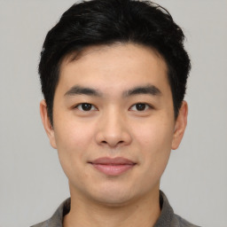 Joyful asian young-adult male with short  black hair and brown eyes