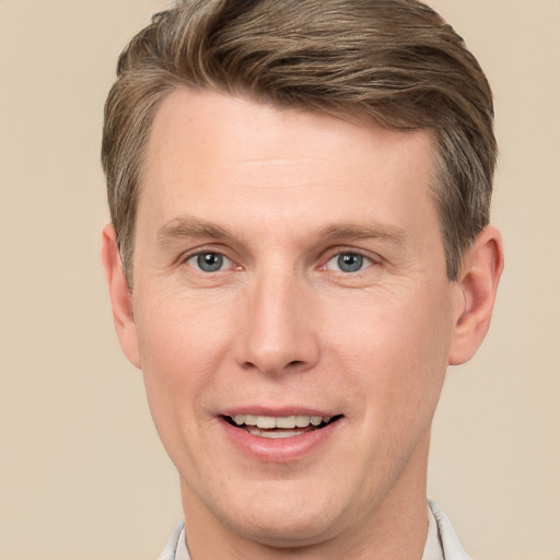 Joyful white young-adult male with short  brown hair and grey eyes