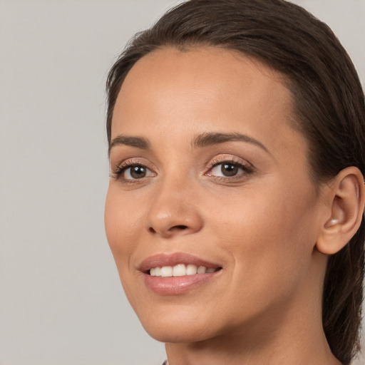 Joyful white young-adult female with long  brown hair and brown eyes