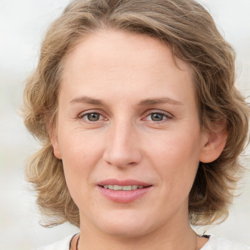 Joyful white young-adult female with medium  brown hair and blue eyes