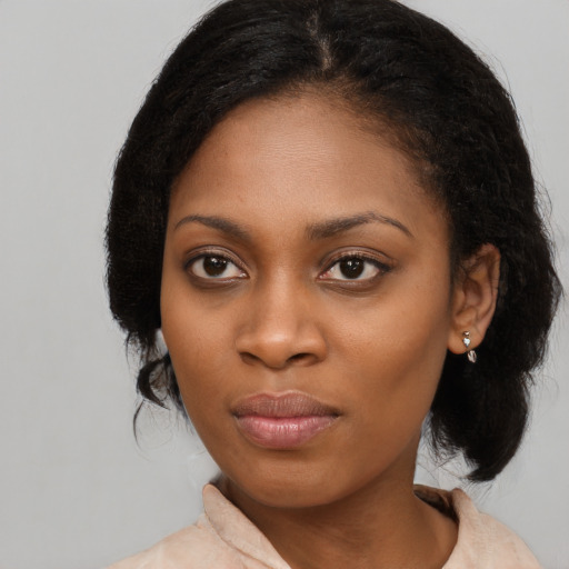 Joyful black young-adult female with long  black hair and brown eyes