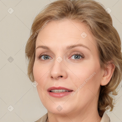 Joyful white adult female with medium  brown hair and blue eyes