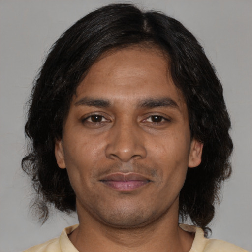 Joyful black adult male with medium  black hair and brown eyes
