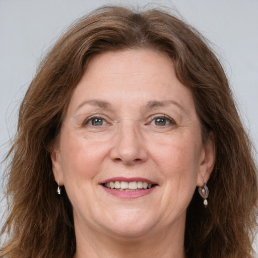 Joyful white adult female with long  brown hair and grey eyes