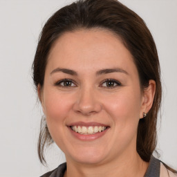 Joyful white young-adult female with medium  brown hair and brown eyes