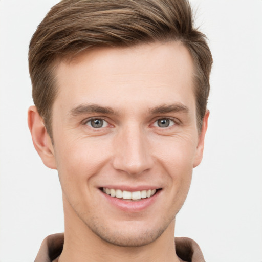 Joyful white young-adult male with short  brown hair and grey eyes