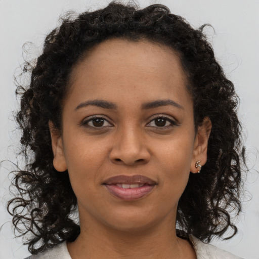 Joyful black young-adult female with medium  brown hair and brown eyes