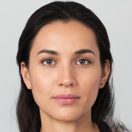 Joyful latino young-adult female with long  brown hair and brown eyes