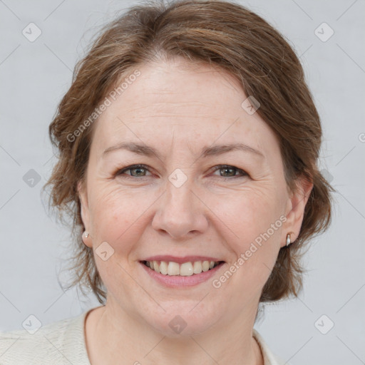 Joyful white adult female with medium  brown hair and grey eyes