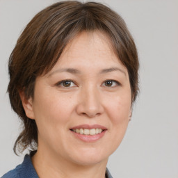 Joyful white adult female with medium  brown hair and brown eyes