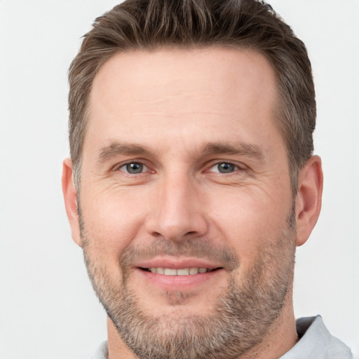 Joyful white adult male with short  brown hair and brown eyes