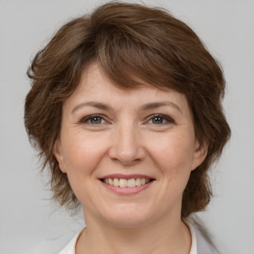 Joyful white adult female with medium  brown hair and brown eyes