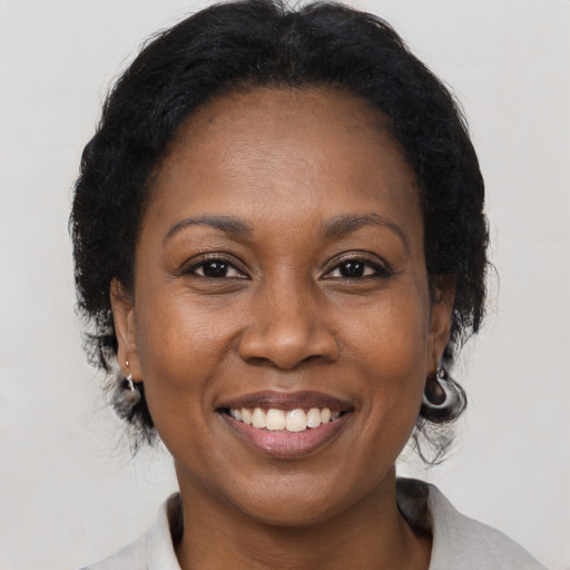 Joyful black adult female with medium  brown hair and brown eyes
