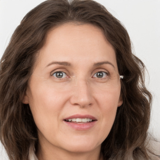 Joyful white adult female with long  brown hair and grey eyes