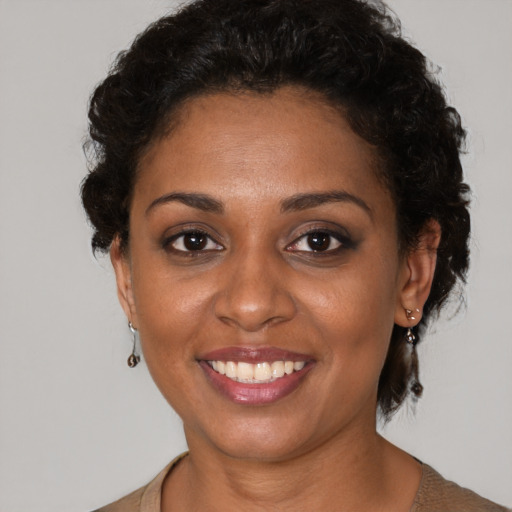 Joyful black young-adult female with short  brown hair and brown eyes