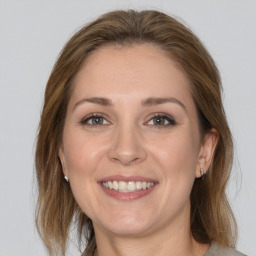 Joyful white young-adult female with medium  brown hair and grey eyes