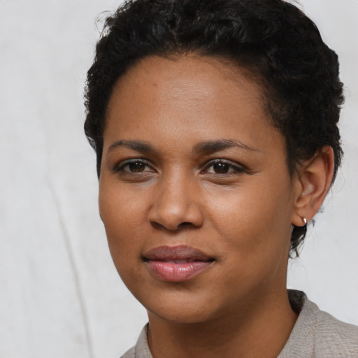 Joyful black young-adult female with short  black hair and brown eyes