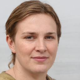 Joyful white young-adult female with medium  brown hair and grey eyes