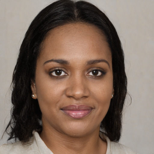 Joyful black young-adult female with medium  brown hair and brown eyes