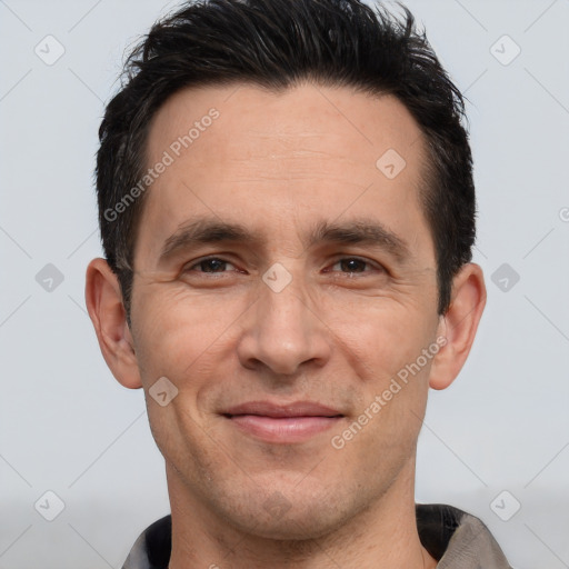 Joyful white adult male with short  black hair and brown eyes