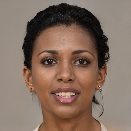 Joyful black young-adult female with medium  brown hair and brown eyes