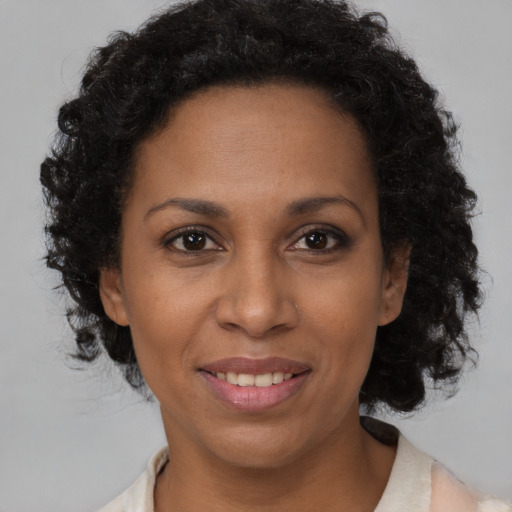 Joyful black adult female with medium  brown hair and brown eyes