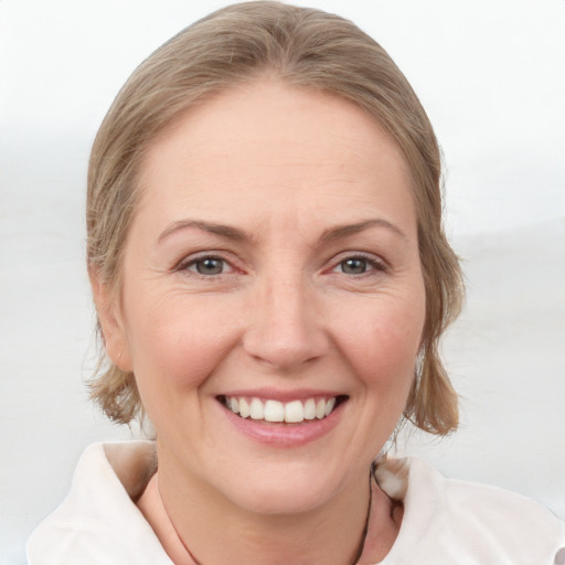 Joyful white adult female with medium  brown hair and grey eyes