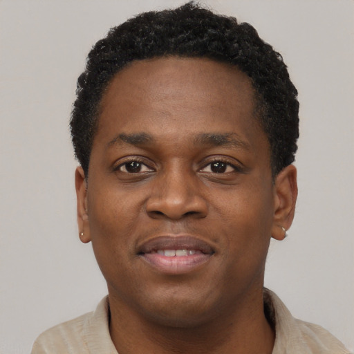 Joyful black young-adult male with short  black hair and brown eyes