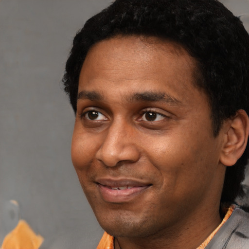 Joyful black young-adult male with short  black hair and brown eyes