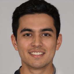 Joyful latino young-adult male with short  brown hair and brown eyes